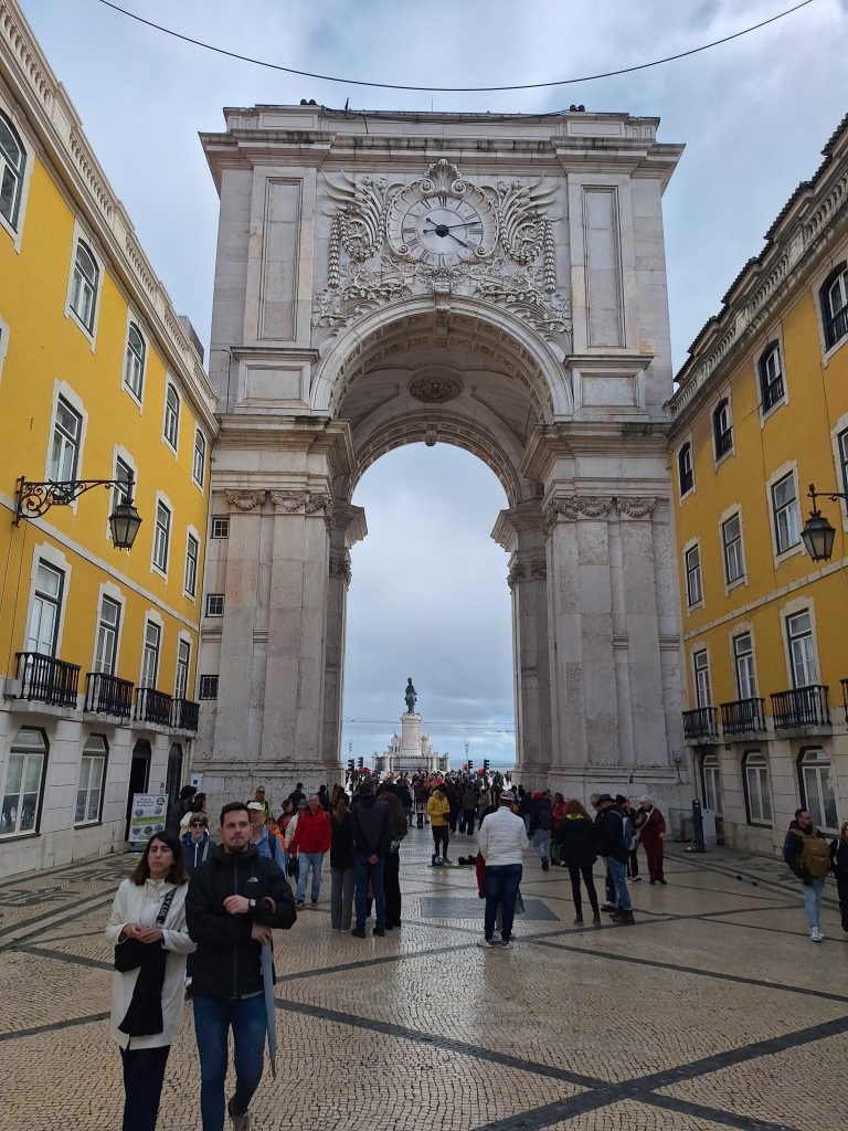 Triumphbogen Arco da Rua Augusta in Lissabon mit Passanten auf dem Platz – Sehenswürdigkeit in Portugals Hauptstadt auf panikontour.de