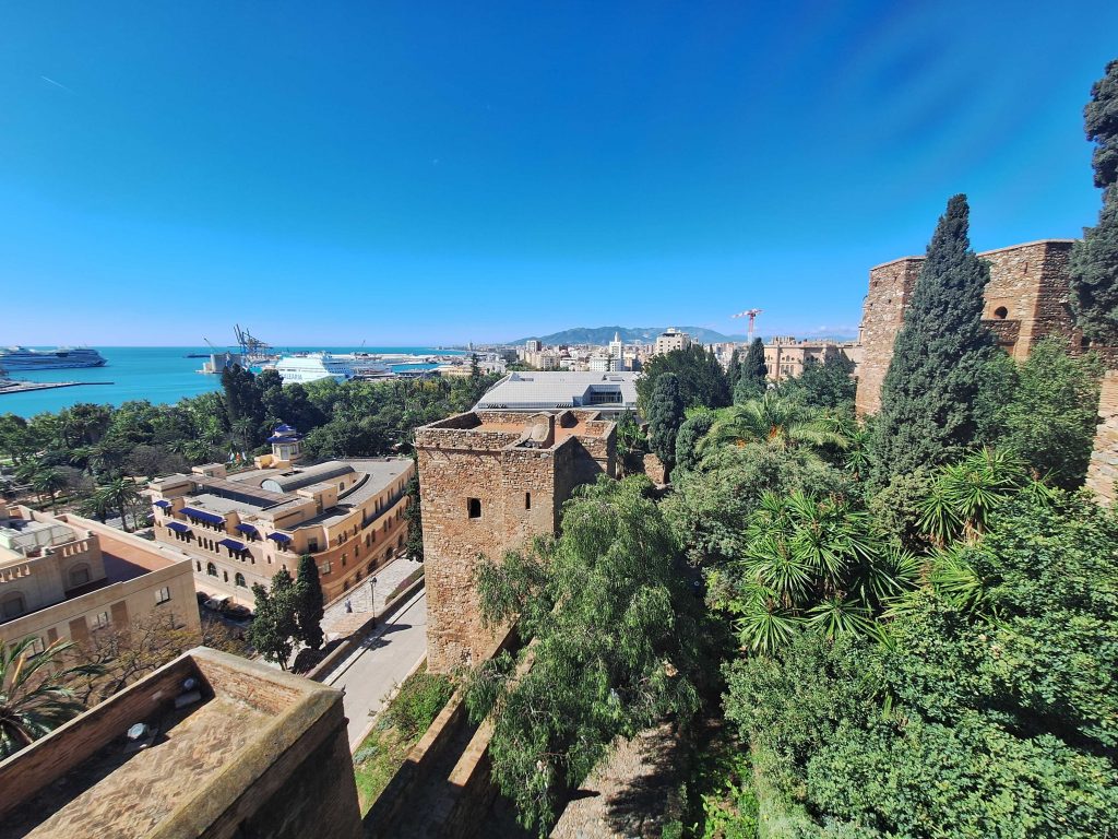 Alcazaba Festung in Málaga mit Blick auf den Hafen und mediterrane Vegetation – Spanienreise auf panikontour.de
