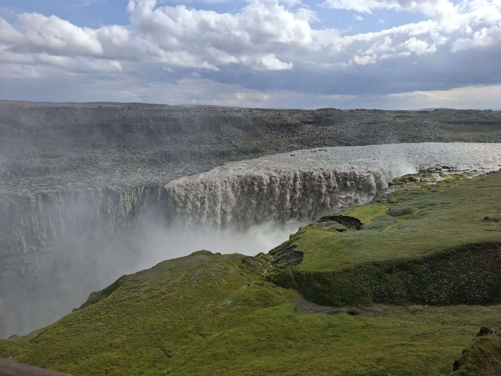 Dettifoss-Wasserfall in Island mit Gischt und grüner Landschaft – stärkster Wasserfall Europas auf panikontour.de