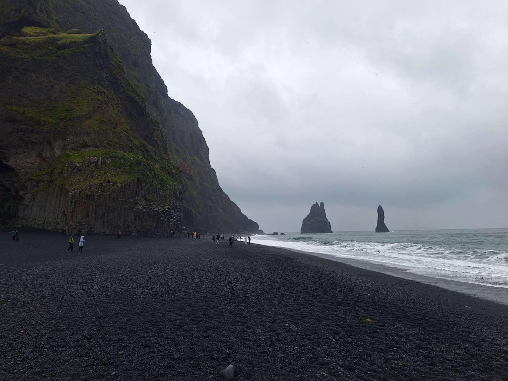 Schwarzer Sandstrand Reynisfjara bei Vik in Island mit Basaltsäulen und Meerblick – eindrucksvolle Naturkulisse auf panikontour.de