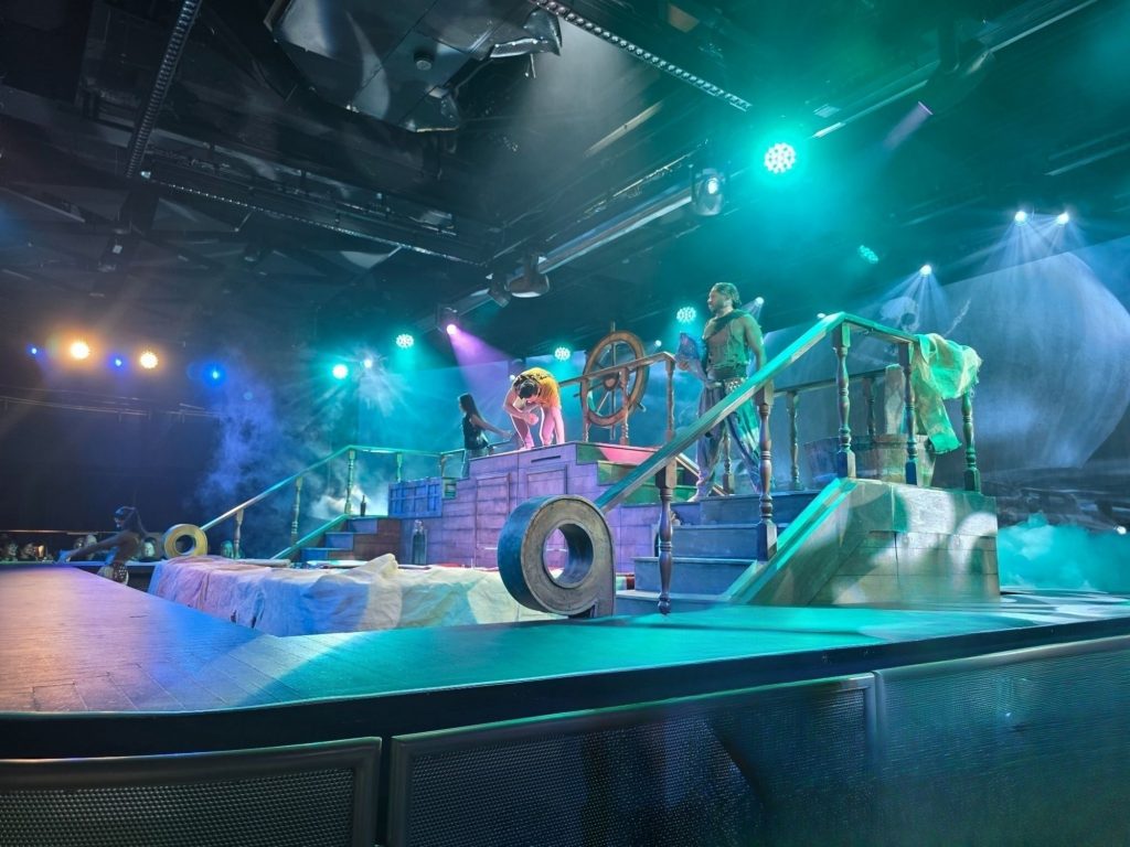 Bühnenauftritt mit farbigem Licht und Nebeleffekten in einem Theater auf Gran Canaria – eine Show voller Energie, Musik und Urlaubsstimmung.