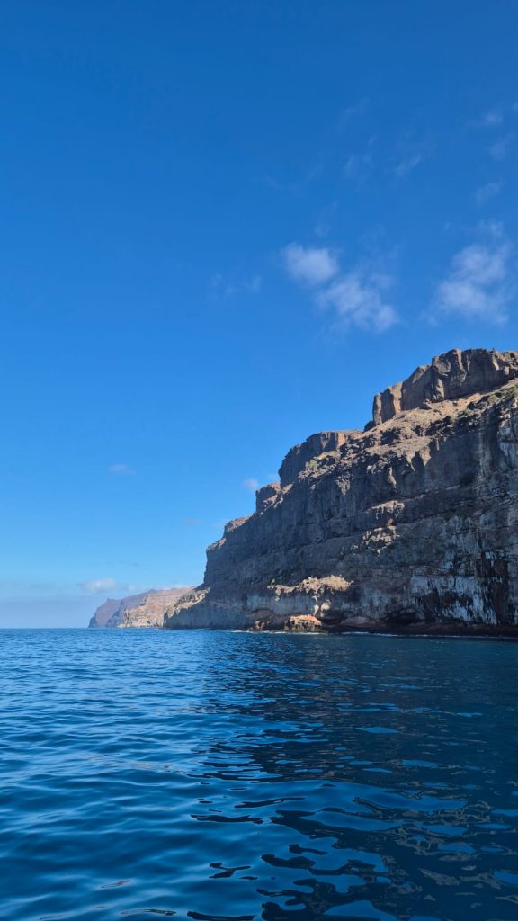Steilküste bei Mogán auf Gran Canaria vom Boot aus – ruhige See und Felsformationen unter blauem Himmel auf panikontour.de