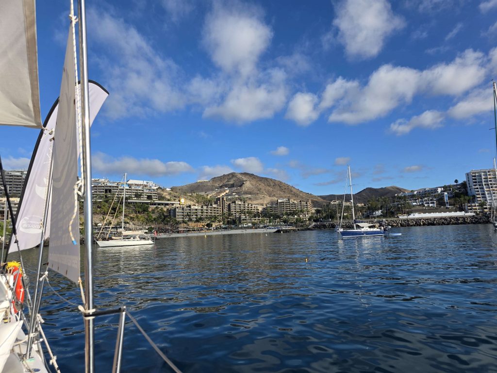 Blick auf Anfi del Mar Gran Canaria vom Segelboot aus – Küste, Hotels und Yachten bei Sonnenschein auf panikontour.de