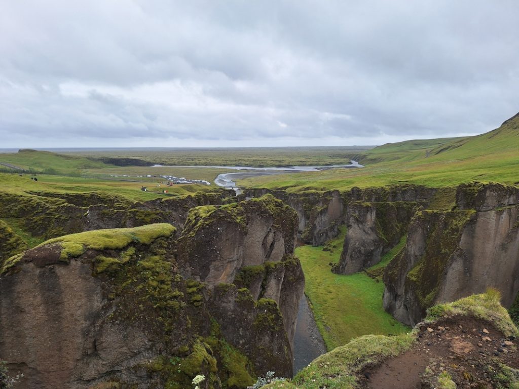 Fjaðrárgljúfur Canyon auf Island – grüne Mooslandschaft und Fluss inmitten weiter Natur
