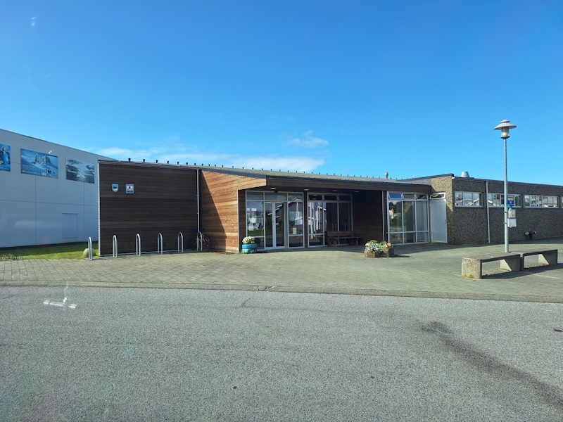 Modernes Schwimmbad in einer kleinen isländischen Stadt unter blauem Himmel