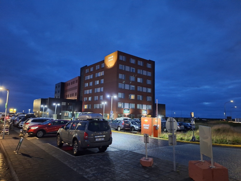 Hotel in Keflavík bei Nacht mit beleuchtetem Parkplatz