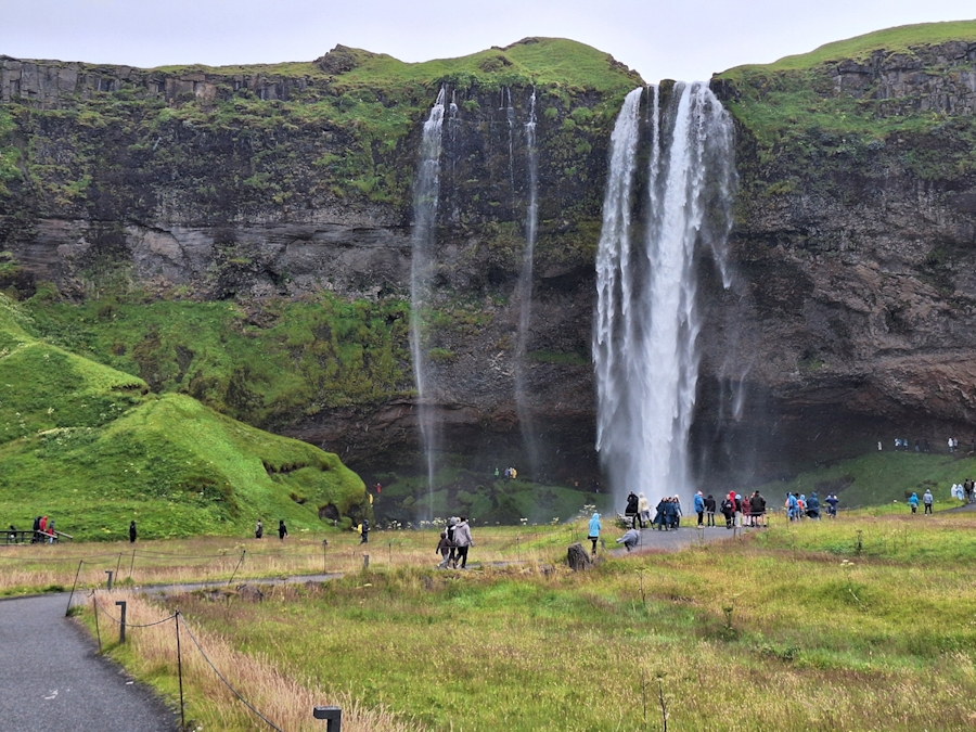 Seljalandsfoss Wasserfall in Island – Besucher vor der eindrucksvollen Felswand