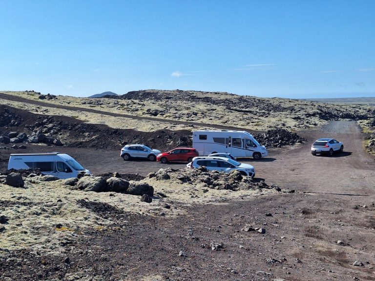 Wohnmobil und Autos auf isländischem Lavafeld – Symbol für Freiheit, Reisen und Mut auf panikontour.de